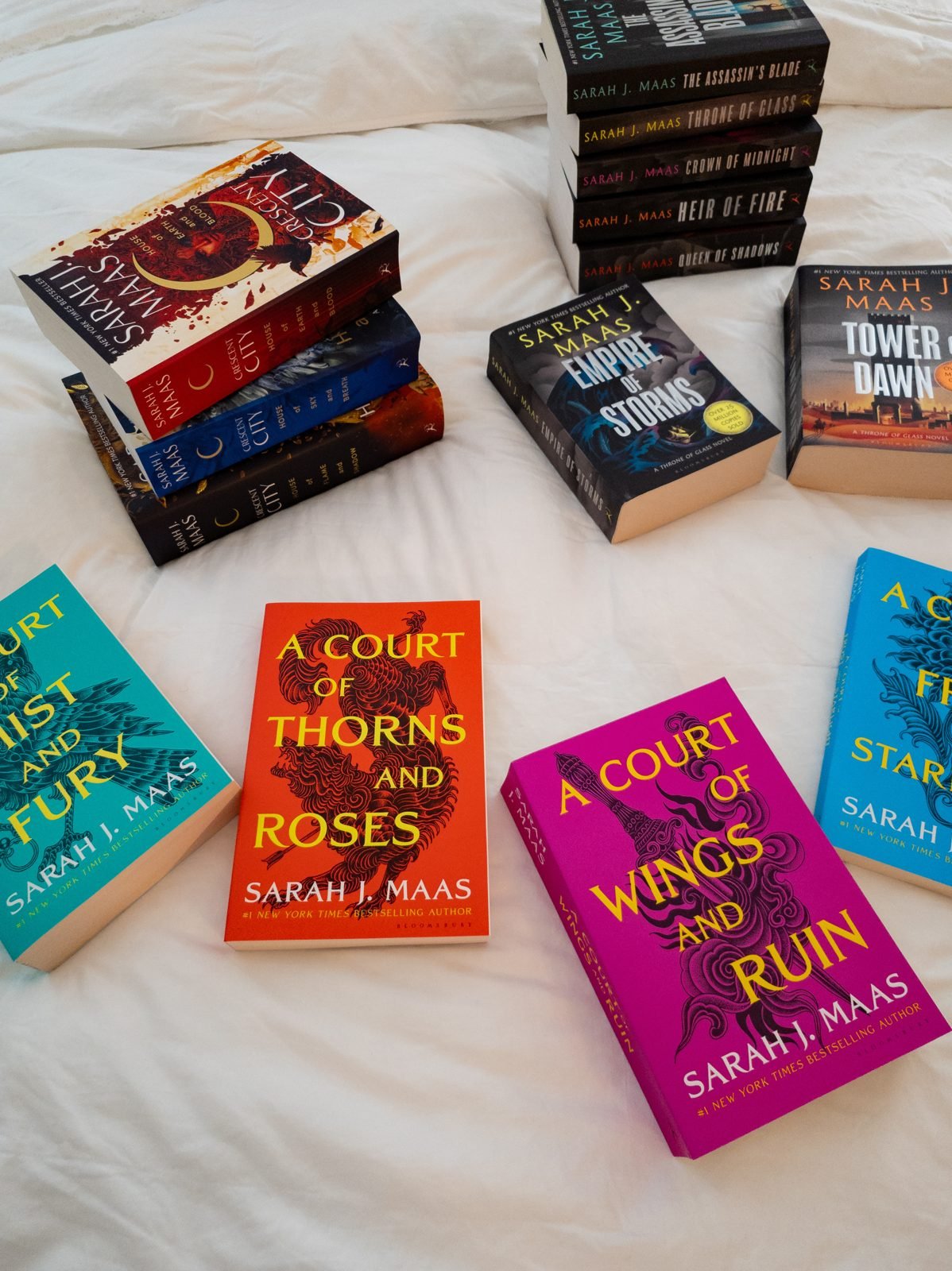 Arielle's Sarah J. Maas collection on a white bed
